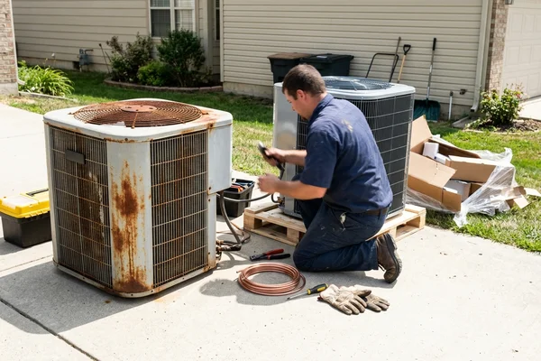 An old condenser next to its replacement during a system changeout